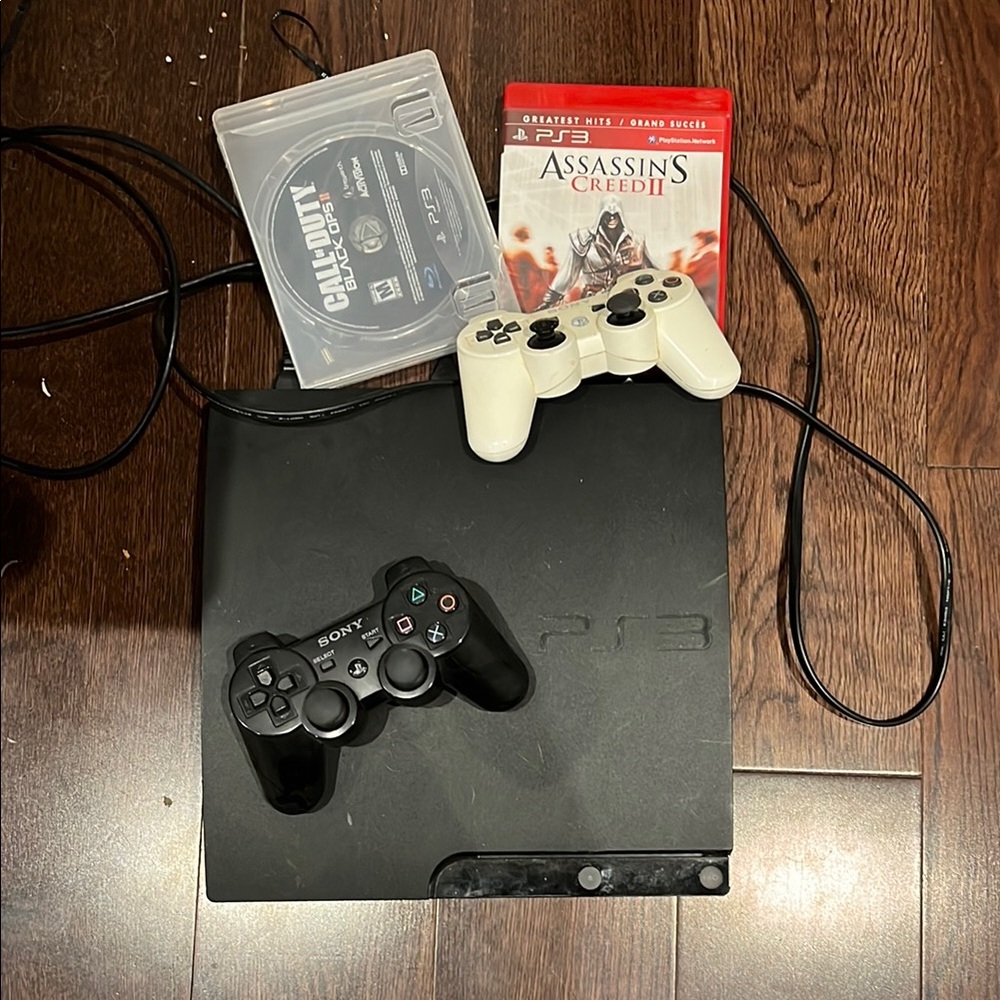 Play station 3 (Ps3)  with black and white controllers and 2 games